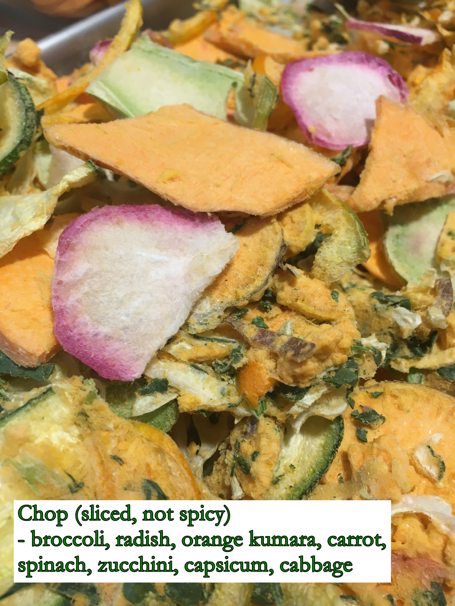 sliced vegetables, freeze-dried to a crisp dry mix - mostly orange with specs of green, red, and white. this mix consists of broccoli, radish, orange kumara, carrot, spinach, zucchini, capsicum, and cabbage.