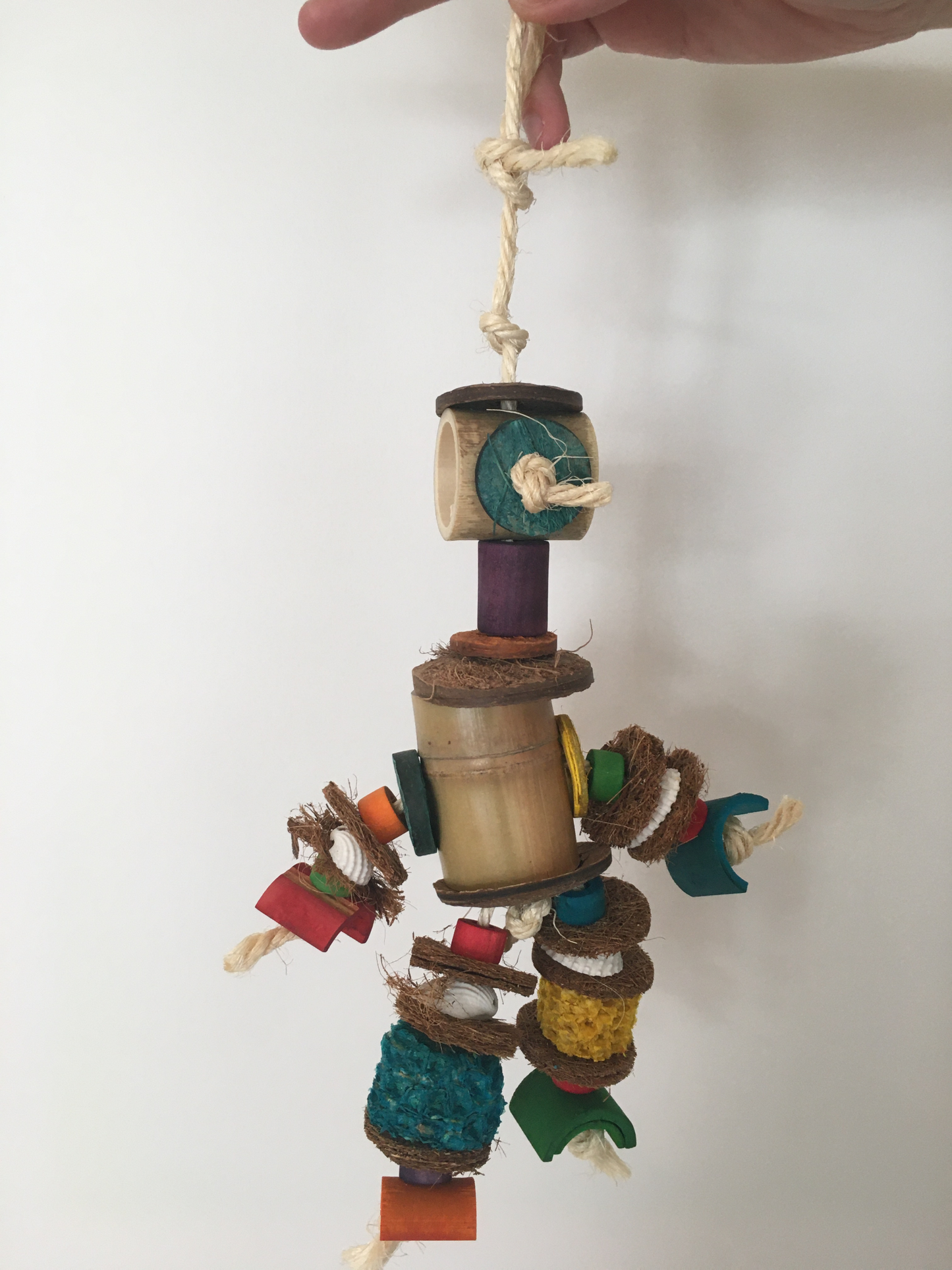 pieces of bamboo, shell, and coconut rough dangling from a string like a little person