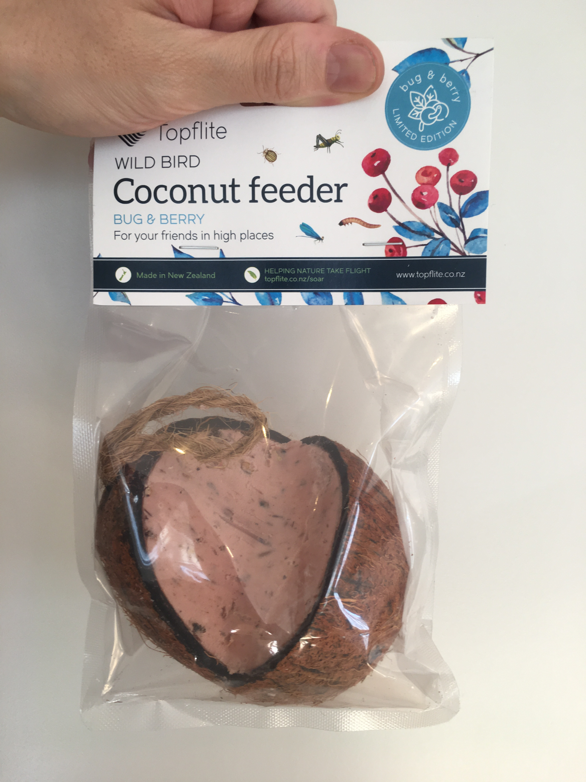 a whole coconut, with a cutout for filling, filled with bug and berry vegetable fat mixture for feeding wild bird. comes with a string, and packaged in a bag.