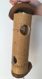 This is a big log toy with holes where you can hide treats. Some corn husks and calcium blocks are already placed inside, and the log is capped off with coconut husks. You could hang the toy vertically