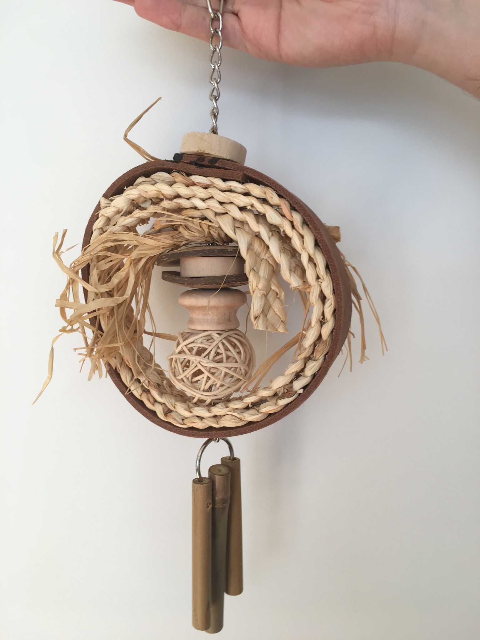 A natural hanging toy for parrots with a ring of sisal weave inside and some dangly chimes. Once the ropes are chewed up, the ring could become a swing.