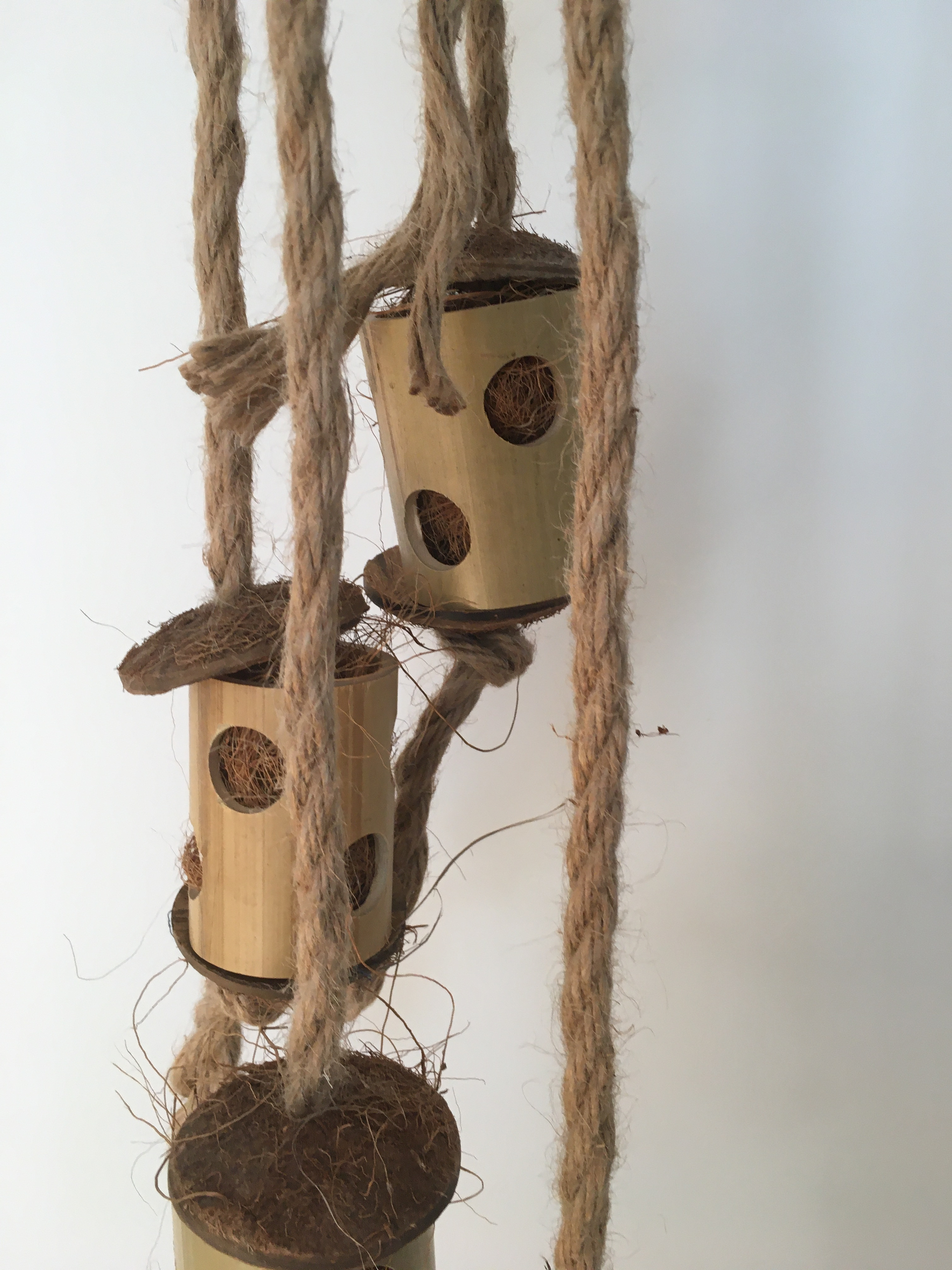 close up of the totem tower parrot toy - jute rope, wooden blocks, and coconut pieces