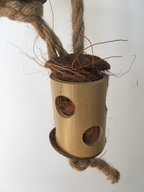 close up of the totem tower parrot toy - jute rope, wooden blocks, and coconut pieces - can be stuffed with treats