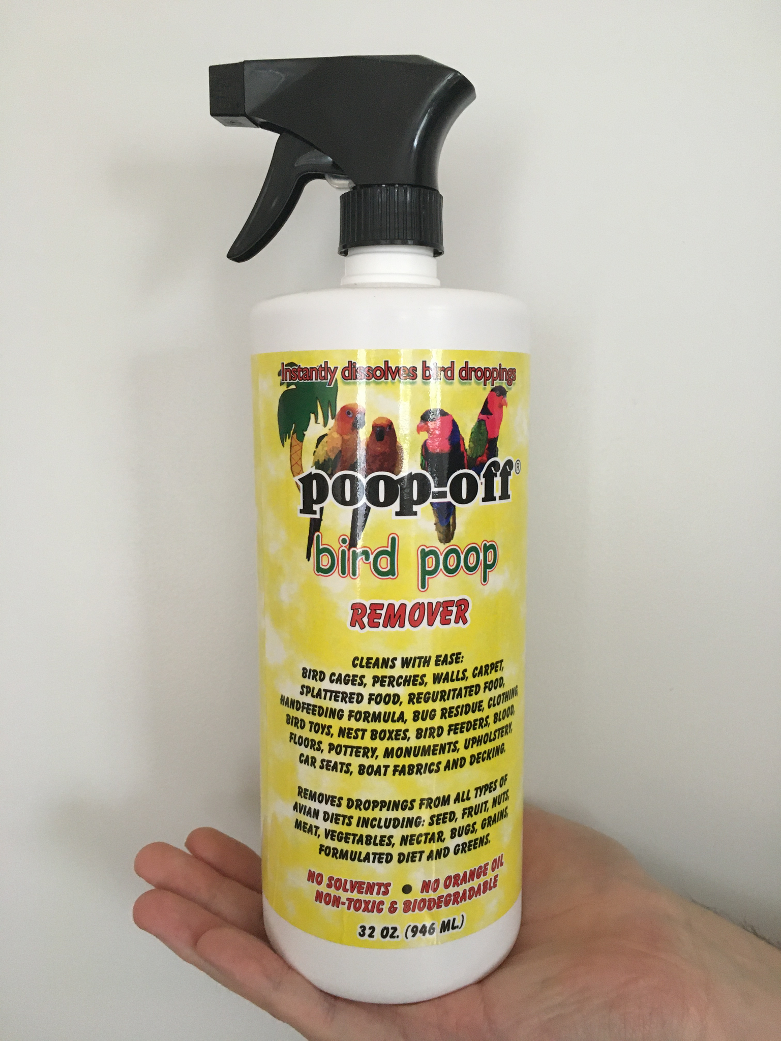 front of the yellow poop-off bottle with descriptions of what it can clean and a spray nozzle attached to the lid
